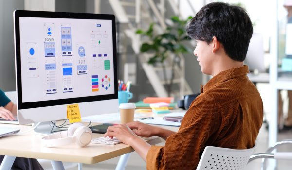 Website designer, Creative planning phone app development template layout framework wireframe design, User experience concept, Young asian man UX designer working on smartphone application at office